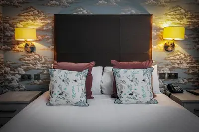 a bedroom with a bed with two pillows and two lamps at The Glendower Hotel in Lytham St Annes