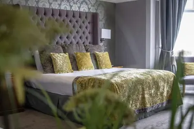 a bedroom with a bed with gold sheets and pillows at The Glendower Hotel in Lytham St Annes