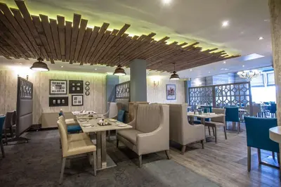 a restaurant with tables and chairs in a room at The Glendower Hotel in Lytham St Annes