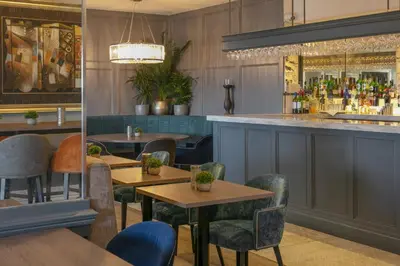 a restaurant with tables and chairs and a bar at The Glendower Hotel in Lytham St Annes