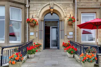 an entrance to a building with flowers and an umbrella at The Glendower Hotel in Lytham St Annes