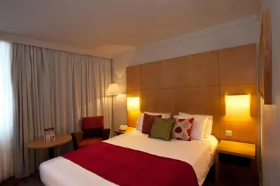 a hotel room with a large bed and a chair at Britannia Hotel Bolton in Bolton