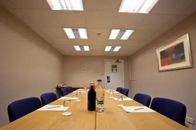 a conference room with a long table and a bottle of wine at Britannia Hotel Bolton in Bolton