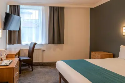 a hotel room with a bed and a desk at Britannia Hotel Bolton in Bolton
