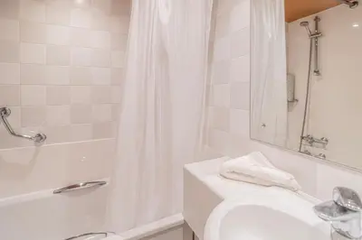 a white bathroom with a sink and a shower at Britannia Hotel Bolton in Bolton