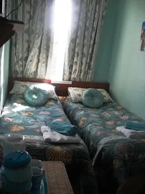 a room with a bed with pillows and a window at Bradleys Hotel in Blackpool
