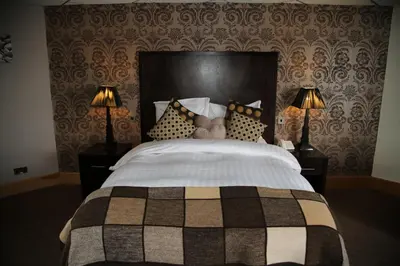 a bedroom with a large bed with two lamps at Inn On The Prom At The Fernlea Hotel in Lytham St Annes