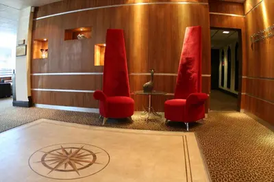 a lobby with two red chairs and a table at Inn On The Prom At The Fernlea Hotel in Lytham St Annes