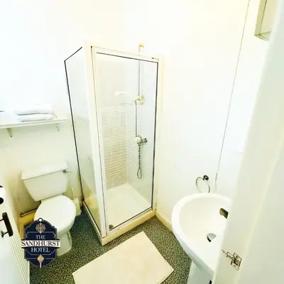 a bathroom with a shower and a toilet and a sink at The Sandhurst Hotel in Blackpool