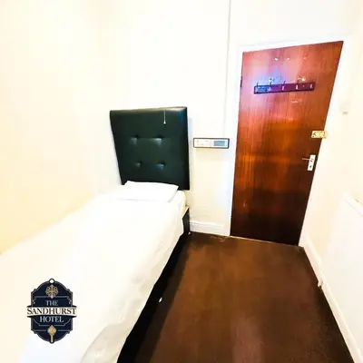 a small room with a bed and a door at The Sandhurst Hotel in Blackpool