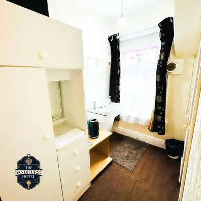 a small bathroom with a sink and a window at The Sandhurst Hotel in Blackpool