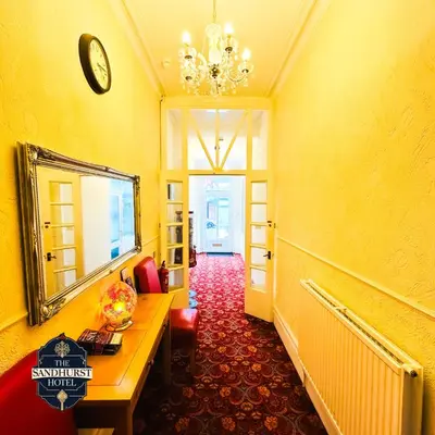 a hallway with a table and a mirror in a room at The Sandhurst Hotel in Blackpool