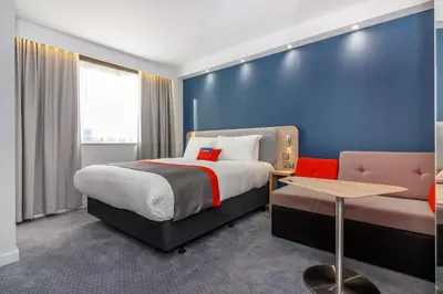 a hotel room with a bed and a couch at Holiday Inn Express - Wigan by IHG in Wigan