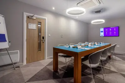 a conference room with a blue table and chairs at Holiday Inn Express - Wigan by IHG in Wigan