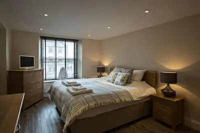 a bedroom with a large bed and a window at Cider House in Ulverston