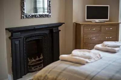 a living room with a fireplace and a television at Cider House in Ulverston