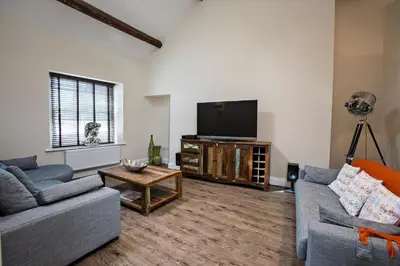 a living room with two couches and a flat screen tv at Cider House in Ulverston