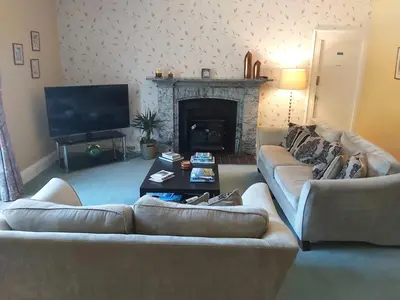 a living room with two couches and a fireplace at Elton Guest House in Grange Over Sands