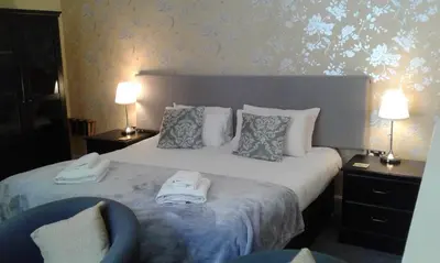 a bedroom with a bed with two towels on it at Elton Guest House in Grange Over Sands