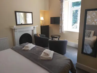 a bedroom with a bed and a fireplace with two towels at Elton Guest House in Grange Over Sands