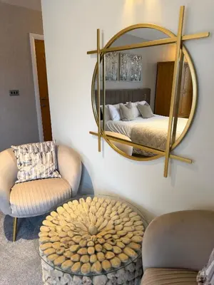a bedroom with a mirror and a bed and a chair at Charnock Farm in Leyland