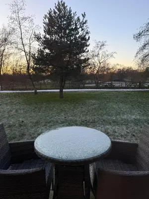 a table and two chairs sitting next to a field at Charnock Farm in Leyland