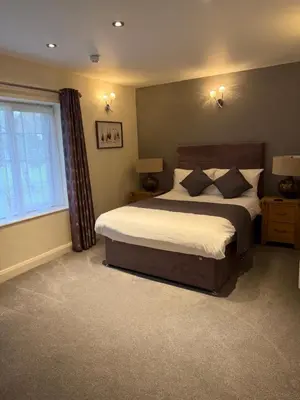 a bedroom with a large bed and a window at Charnock Farm in Leyland