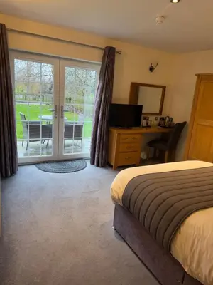 a bedroom with a bed and a desk and sliding glass doors at Charnock Farm in Leyland