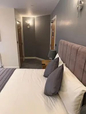a bedroom with a large bed with two pillows at Charnock Farm in Leyland