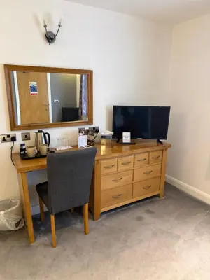 a desk with a television and a table with a chair at Charnock Farm in Leyland