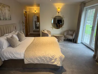 a bedroom with a bed and a living room at Charnock Farm in Leyland