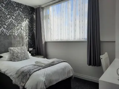 a bedroom with a bed and a large window at Balmoral in Morecambe