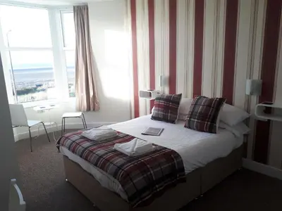 a hotel room with a bed and a window at Balmoral in Morecambe