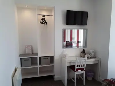 a room with a desk and a tv on a wall at Balmoral in Morecambe