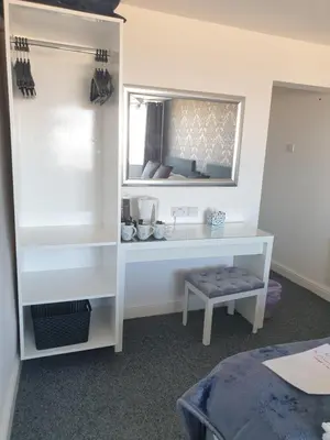 a bedroom with a mirror and a white desk at Balmoral in Morecambe