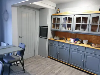 a kitchen with blue cabinets and a table and chairs at Balmoral in Morecambe