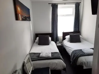 two beds in a small room with a window at Balmoral in Morecambe