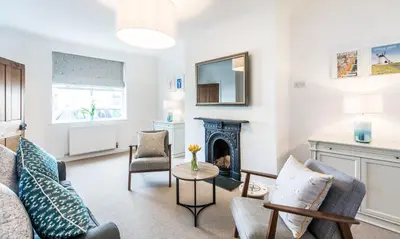 a living room with a fireplace and chairs at Lobster Cottage Lytham in Lytham St Annes