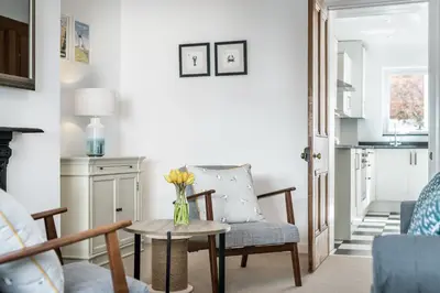 a living room with a vase of flowers on a table at Lobster Cottage Lytham in Lytham St Annes