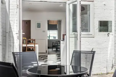 a dining room with a glass table and chairs at Lobster Cottage Lytham in Lytham St Annes