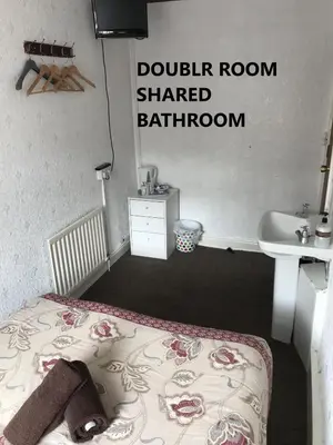 a small bedroom with a bed and a sink at Coco Beach Hotel in Blackpool