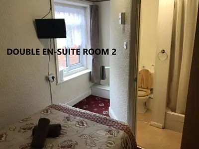 a room with a bed and a bathroom with a window at Coco Beach Hotel in Blackpool