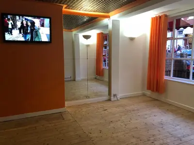 a room with a television on the wall and a hallway at Coco Beach Hotel in Blackpool