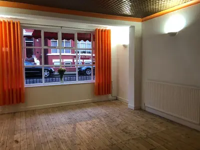 an empty room with a window with orange curtains at Coco Beach Hotel in Blackpool