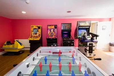 a games room with a table and arcade games at Dalmeny Hotel in Lytham St Annes