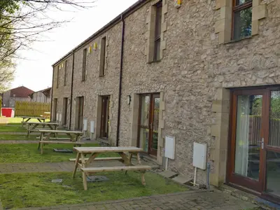 a group of picnic tables in front of a brick building at Tewitfield Marina in Carnforth