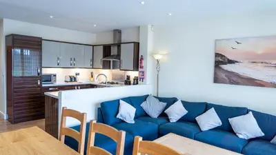 a living room with a blue couch and a kitchen at Tewitfield Marina in Carnforth