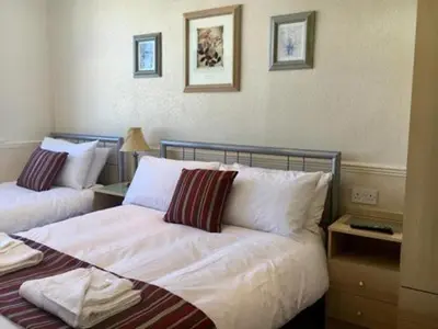 a bedroom with two beds with white sheets and pillows at Seagull Hotel in Blackpool