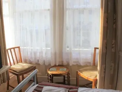 a bedroom with two chairs and a table and a window at Seagull Hotel in Blackpool