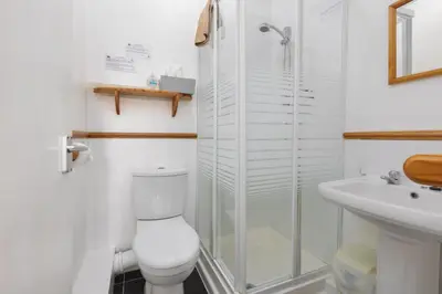 a bathroom with a shower and a toilet and a sink at The Fairmile in Lytham St Annes
